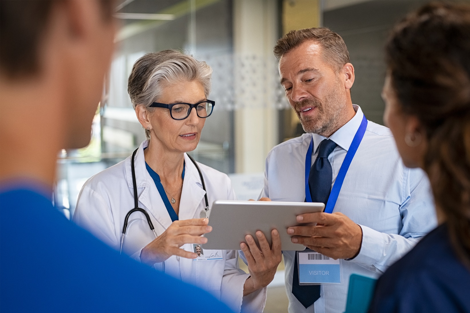 Photo of doctors and nurses talking looking at a tablet computer