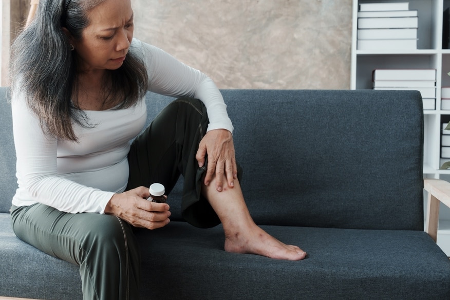 a person on a sofa with a medicine bottle