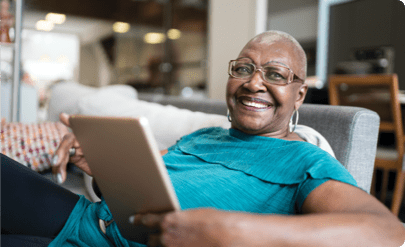 Smiling woman on a couch holding a tablet